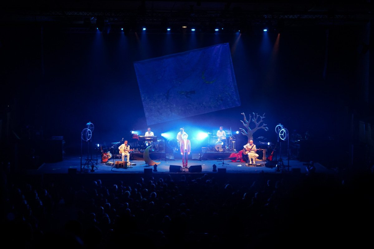 Scenografia con giardino sospeso e aquiloni in proiezione