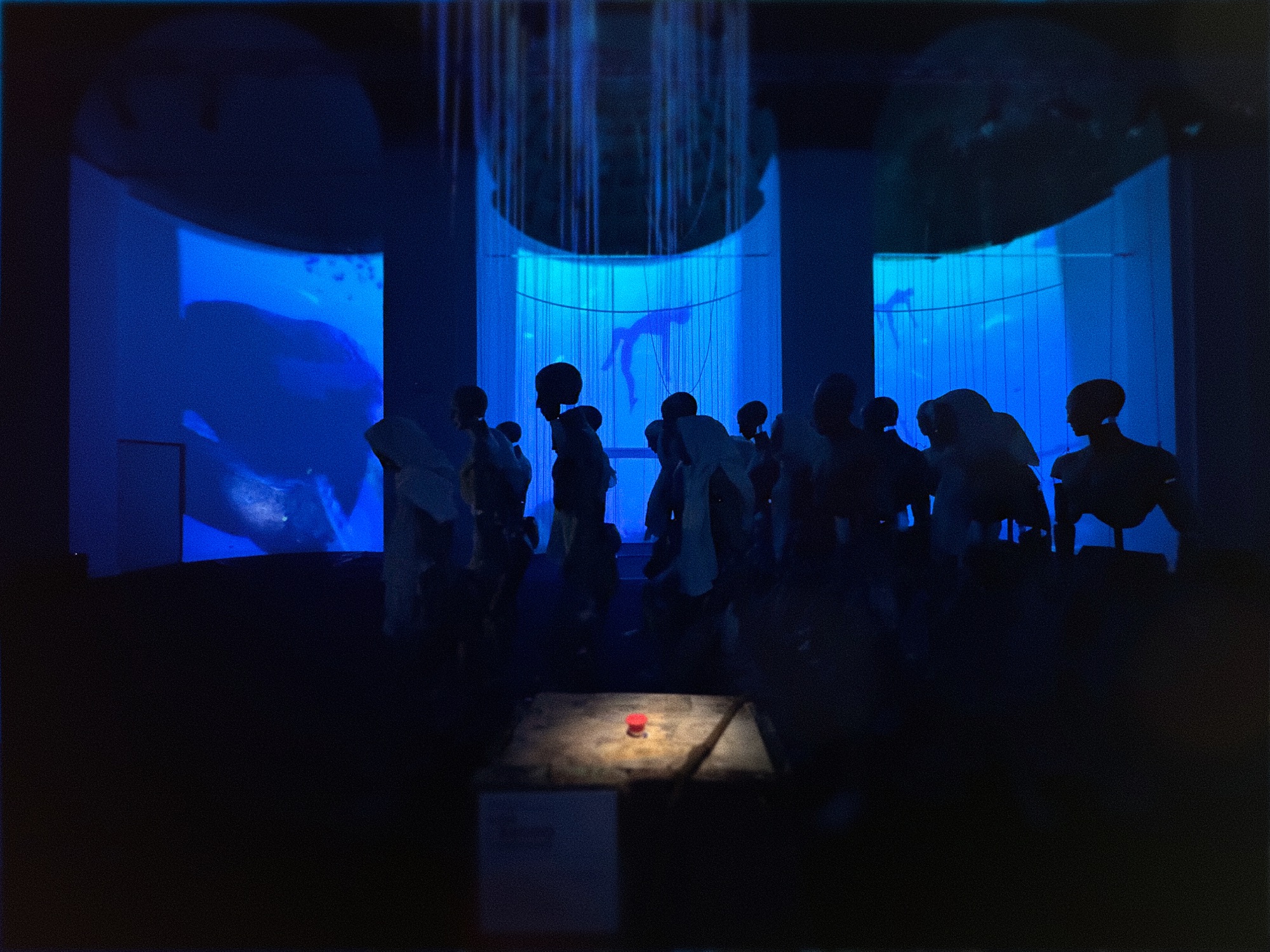 Veduta d'insieme dell'installazione AIDA con figure in silhouette e videomapping immersivo