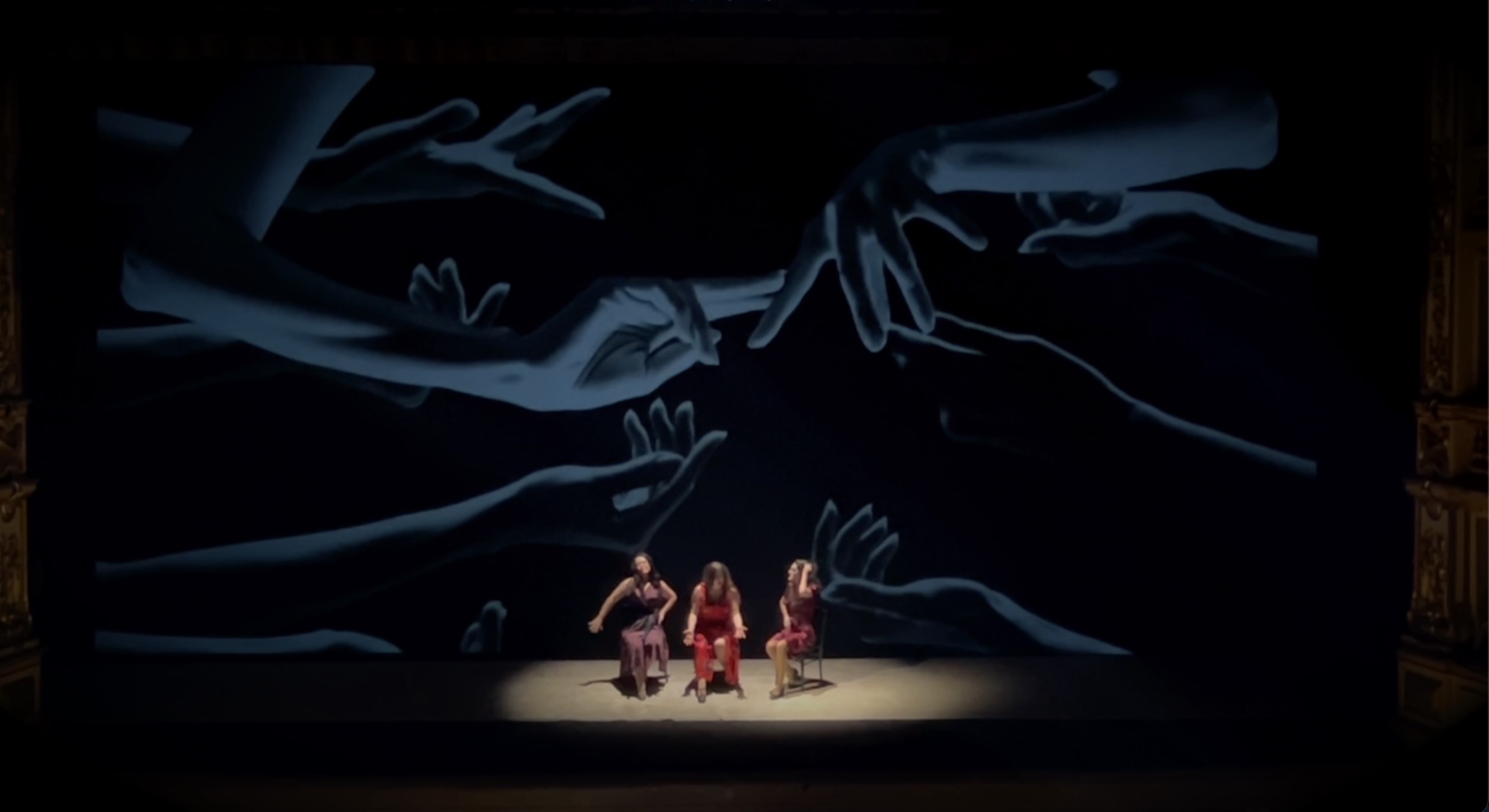 Scena della Carmen con proiezioni di mani generate dall'AI al Teatro Grande di Brescia