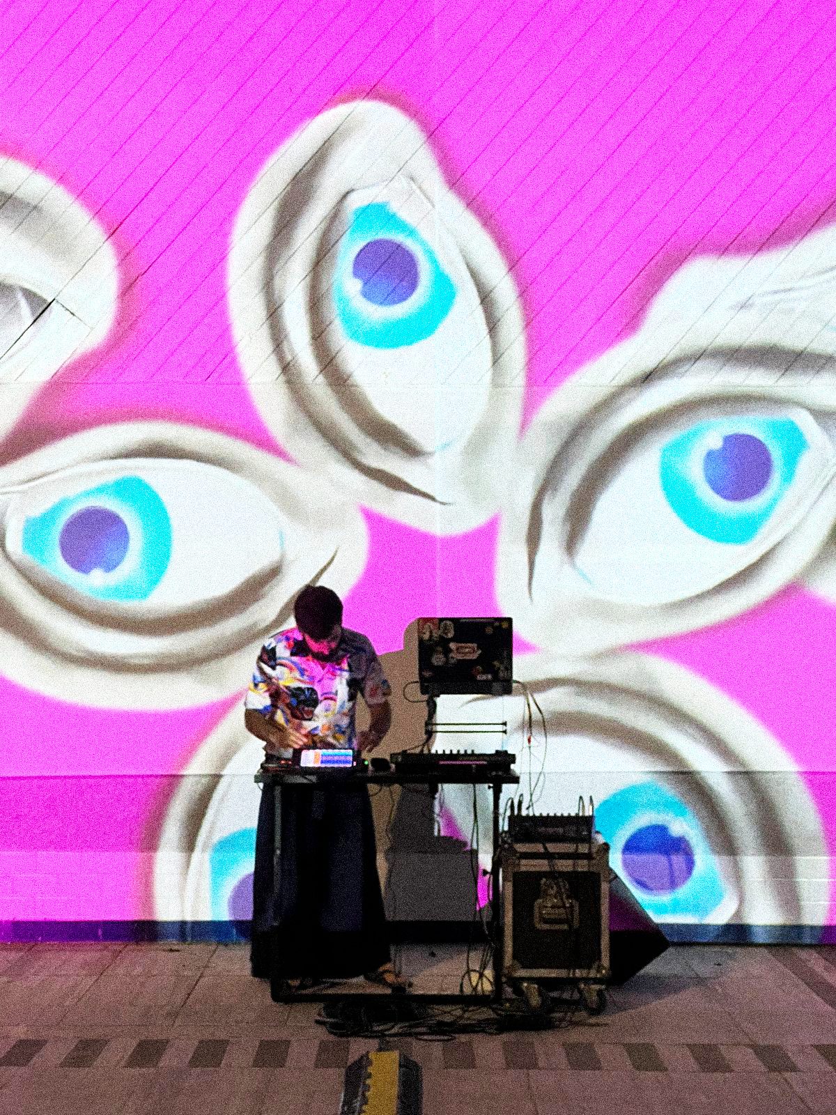 FANTASTIK - Davide at the console in front of the wall of hand-drawn eyes
